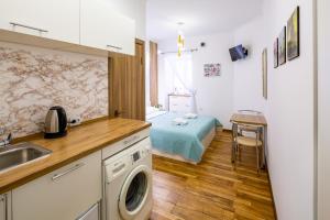a kitchen with a sink and a bed in a room at Cozy apartments center in Lviv