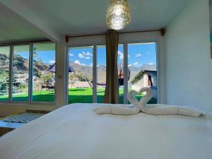 a bedroom with a large white bed with a large window at DUBAI by luxury Atitlan in San Pedro La Laguna +57 photos