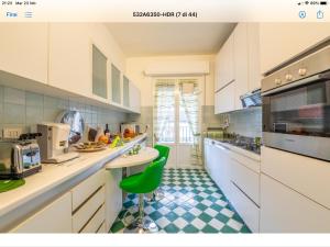 a kitchen with white cabinets and a green stool at Le Tre Torri in Parma