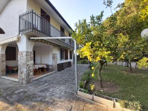 a house with a patio and a tree in the yard at Villa l'Amante in Fondi
