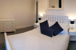 sypialnia z białym łóżkiem z 2 niebieskimi poduszkami w obiekcie Apartment 124 w mieście Fife