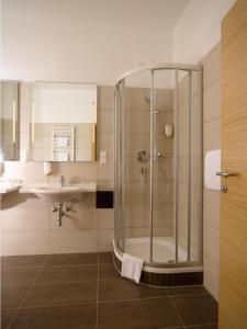 y baño con ducha y lavamanos. en Hotel Drei Raben, en Graz