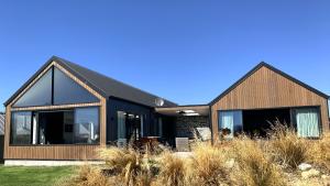 uma casa com um telhado preto e janelas grandes em The Landsborough Tekapo em Lake Tekapo