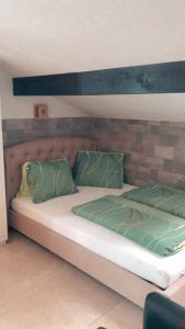 ein Bett mit zwei grünen Kissen darüber in der Unterkunft Apartment Lala in Interlaken