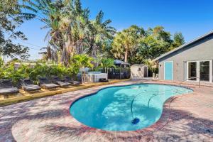 a swimming pool in the backyard of a house with palm trees at Pompano Beach House in Pompano Beach