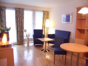 a living room with a table and blue chairs and a table and a tablektop at TopDomizil Apartments Checkpoint Plaza in Berlin +10 photos