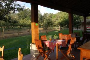 a table and chairs on a patio with a view of a yard at La Galamperna in Nava del Barco