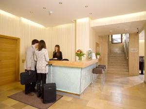 a man and woman kissing at a counter in a lobby at Hotel Drei Raben in Graz