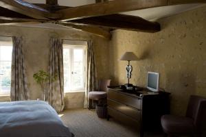 a bedroom with a bed and a desk with a computer on it at Coté Parc in Rémalard en Perche