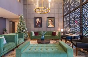 a living room with green couches and a christmas tree at Sandman Signature Ottawa Airport Hotel in Ottawa