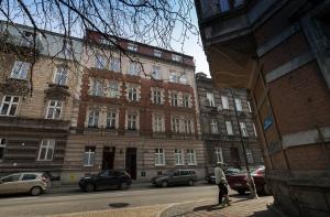 un hombre caminando por una calle en frente de un edificio en Home in Krakow Silvio's Apartments, en Cracovia