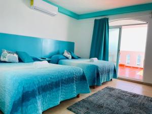 a bedroom with two beds and a large window at Habitación Amanecer Turquesa #2 in Isla Mujeres