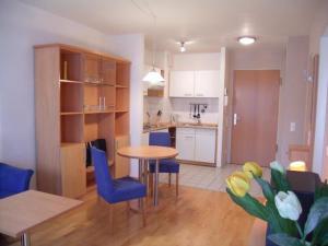 a kitchen and dining room with a table and blue chairs at TopDomizil Apartments Checkpoint Plaza in Berlin