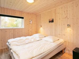 a large bed in a room with wooden walls at 12 person holiday home in Hals in Hals