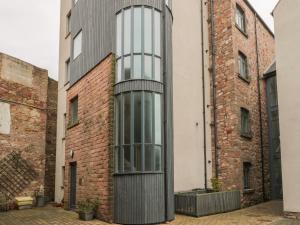 a tall brick building with a glass facade at 5 Mill Wharf in Berwick-Upon-Tweed
