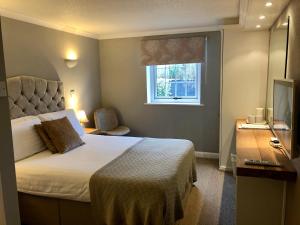 um quarto com uma cama, uma janela e uma televisão em String Of Horses em Carlisle