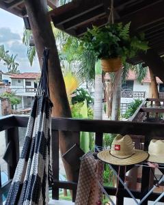 a hammock on a balcony with a hat on it at Flat 14 Pipa in Pipa