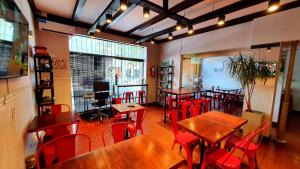 a restaurant with wooden tables and red chairs at Hotel Positano in Mar del Plata