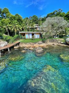 a pool of water with a house in the background at Verde Mar Pousada in Angra dos Reis
