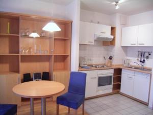 a kitchen with a wooden table and blue chairs at TopDomizil Apartments Checkpoint Plaza in Berlin