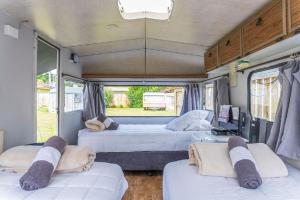 a bedroom with three beds in a rv at Leithfield Beach Holiday Park in Leithfield