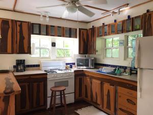 eine Küche mit Holzschränken und einem weißen Herd mit Backofen in der Unterkunft Alta Vista Vacation Home in Caye Caulker