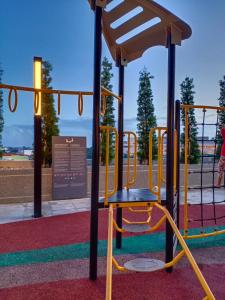 a playground in a park with a yellow swing at TROIKA DREAM HOME in Kota Bharu +2 photos