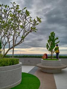 a couple of people standing next to two trees at TROIKA DREAM HOME in Kota Bharu