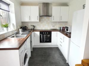 a white kitchen with a sink and a dishwasher at Accommodation in Stevenage 2 bedrooms in Stevenage