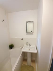 y baño blanco con lavabo y bañera. en Accommodation in Stevenage 2 bedrooms, en Stevenage