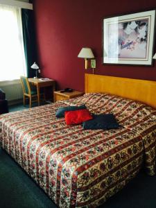 a bed in a hotel room with a red wall at Hotel Mayflower in Leiden