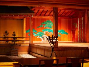 un palco con un dipinto di alberi sul muro di Yamatoya Honten a Matsuyama