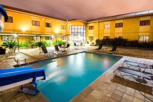 una piscina cubierta en un hotel con sillas y mesas en Hotel Nacional Inn Sorocaba, en Sorocaba
