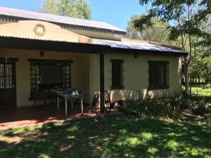 una casa con una mesa delante en Baradero - La vida de campo a una hora del Obelisco! km142 R9 - las chapas casa de campo baradero en Baradero