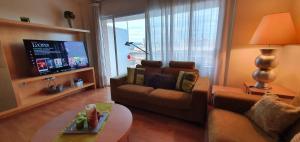 a living room with a couch and a tv at Central Park Salou VIP in Salou
