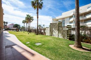 a park with palm trees next to a building at Zurich 47 by homeprive in Denia