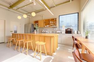 a kitchen with a wooden counter and stools at Upflo Hostel in Seoul