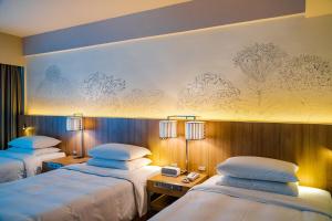 a hotel room with two beds and a wall mural at Renaissance Okinawa Resort in Onna +84 photos