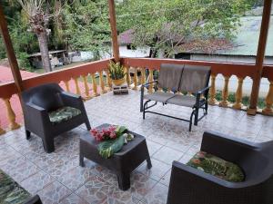 a patio with chairs and a table with flowers on it at Cupido - Playa Tambor in Tambor