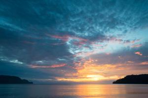 a sunset over the water with a cloudy sky at Cupido - Playa Tambor in Tambor