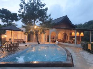 a swimming pool in front of a house at Villa Stella By The Villas 100 in Bogor