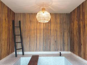 a room with a chandelier and a table and a ladder at Villa Stella By The Villas 100 in Bogor +48 photos