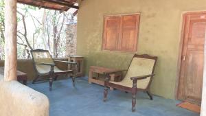 three chairs and a table on a patio at Kamatha Eco Lodge in Habarana