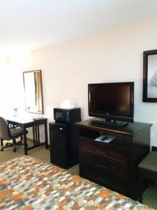 a hotel room with a bed and a flat screen tv at Country Hearth Inn & Suites - Kenton in Kenton