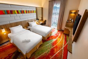 a hotel room with two beds and a desk at Eastin Hotel Penang in Bayan Lepas +25 photos