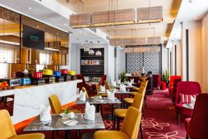 un restaurante con mesas y sillas y un bar en Eastin Hotel Penang en Bayan Lepas