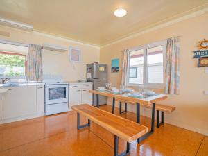 uma cozinha com uma mesa com copos em Poppy's Beach House - Beachfront Whangapoua Home em Whangapoua