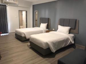 a hotel room with two beds with white sheets at Neo Hotel in Khon Kaen