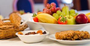 a table topped with bowls of fruits and vegetables at Eco Friendly Hotel Dália in Košice