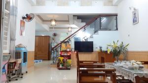 uma sala de estar com uma escada e mesas e cadeiras em Ngoc Diep Homestay Hoi An em Hoi An